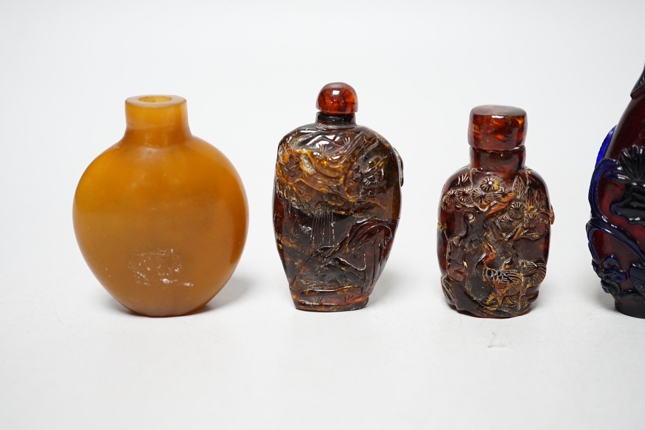 Five Chinese glass or amber snuff bottles, 7.4 cm high